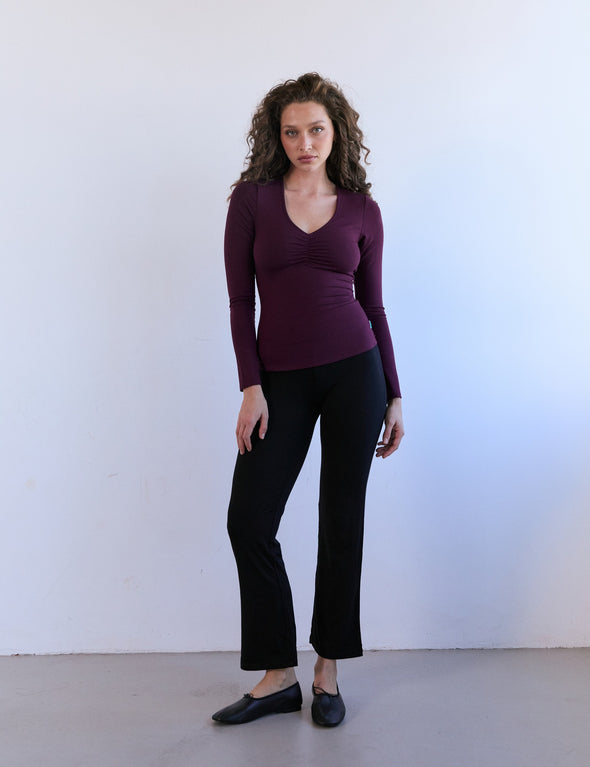 Pantalon SASHA Noir-Ebène porté en pied, de face, par Talia (36), avec le Nobratop® CARLOTTA Plum-Aura